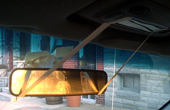[photo of mirror held on with tape]